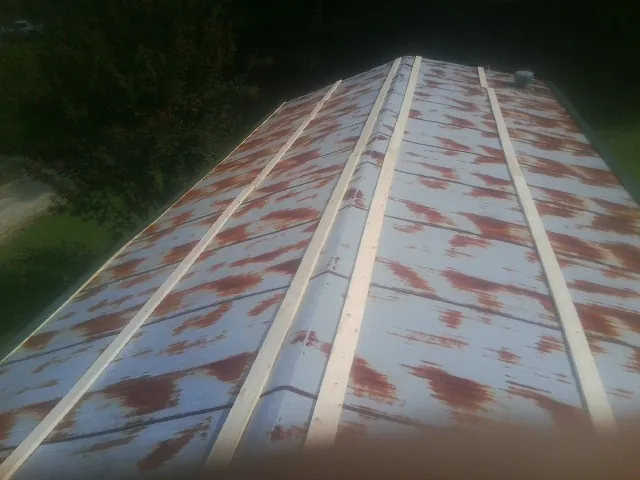 Rusted metal roof panels with new wood purlins before replacement — Storm Damage Roof Repair in Harvard by Roofing Brothers