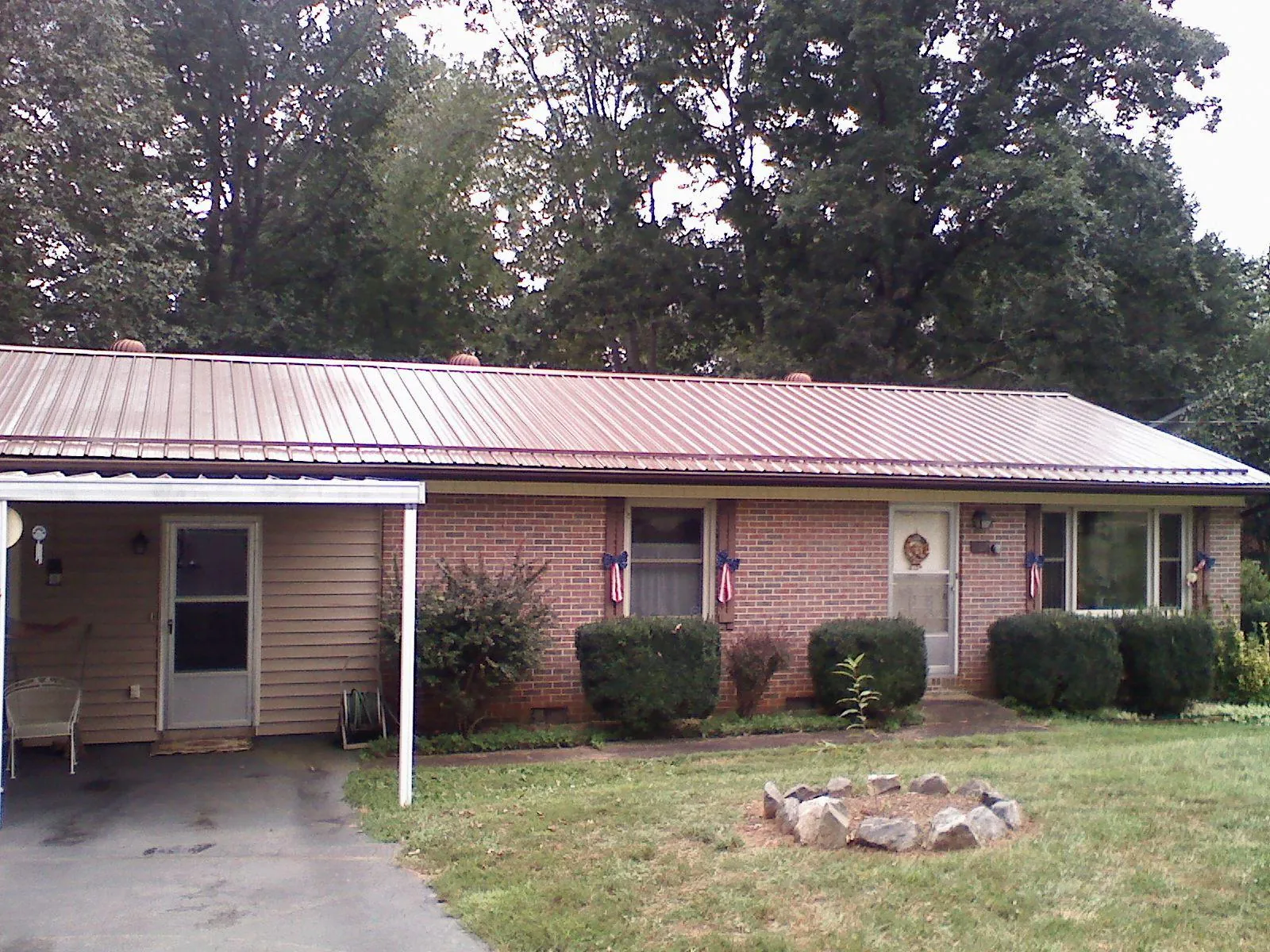 Bronze metal roof and carport on a brick ranch home — Roof Repair work by our crew in Harvard